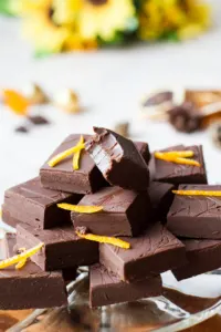 A stack of chocolate fudge, one is taken a bite of.