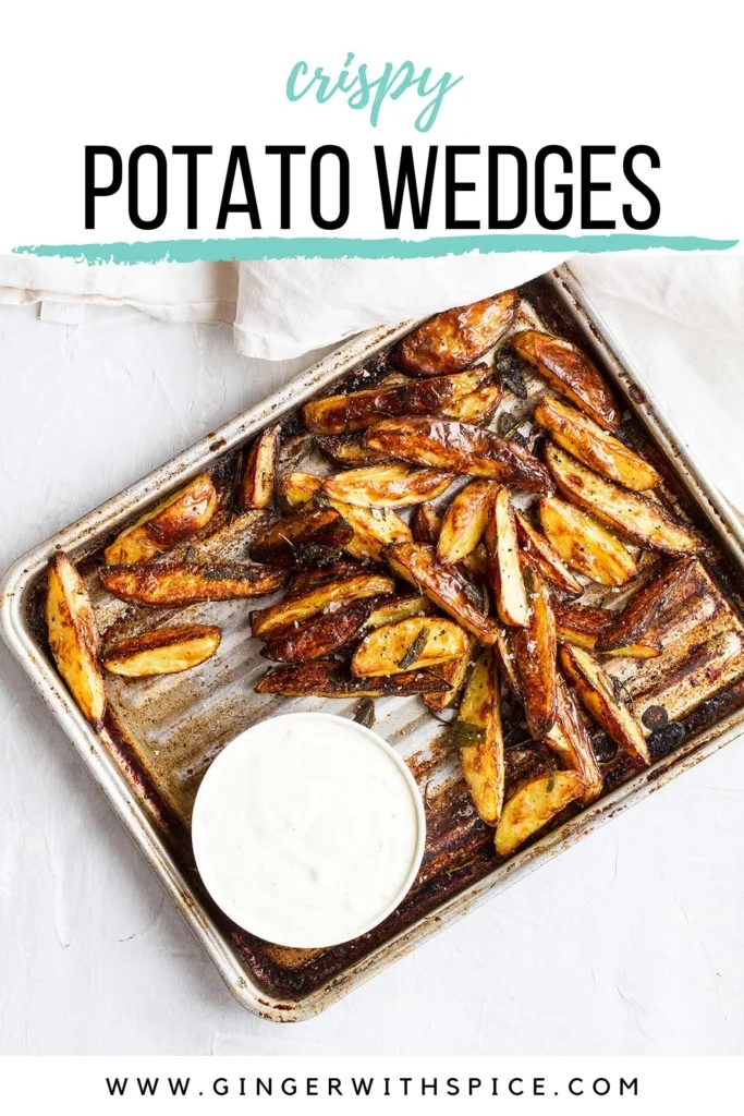 An old baking sheet with rustic, crispy potatoes and a small bowl with pickle dip. Pinterest pin.
