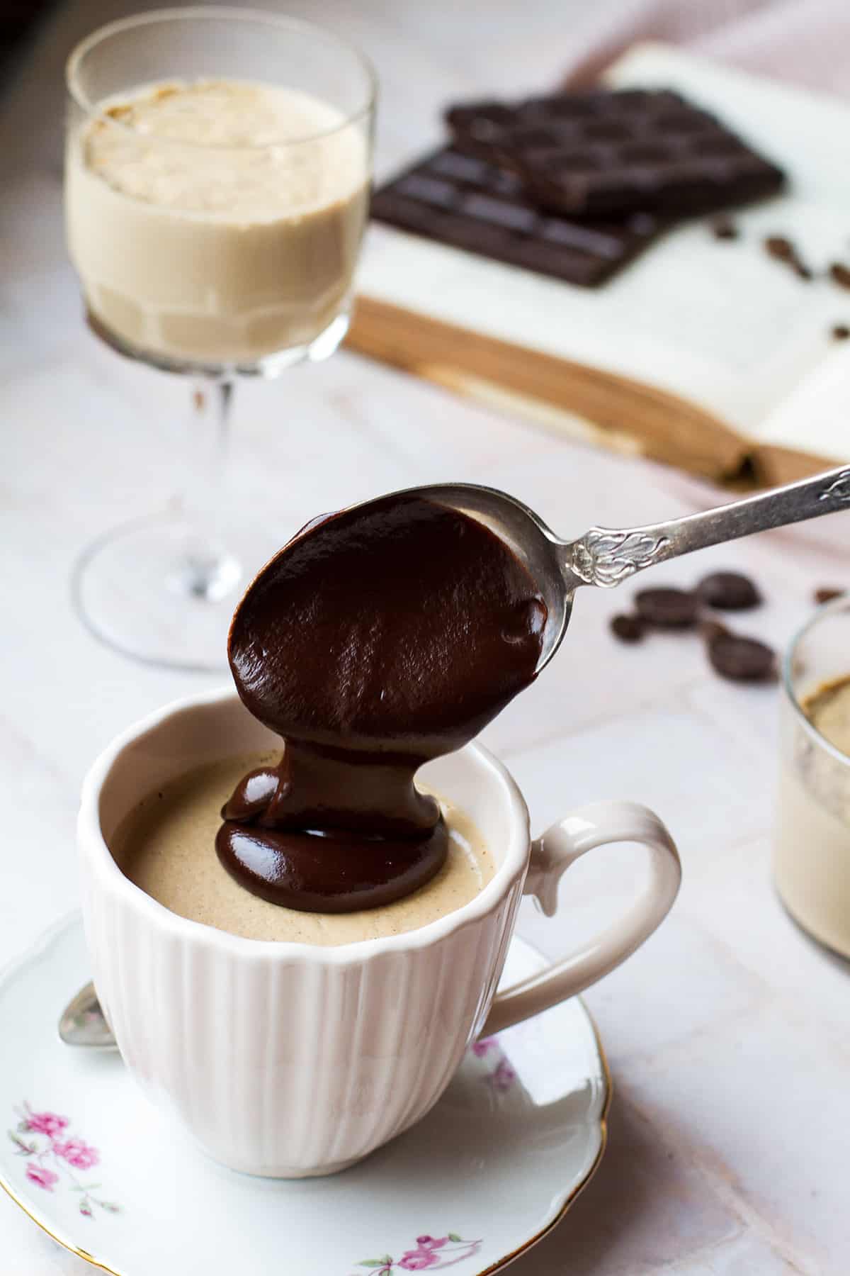 Pouring thick chocolate ganache on top of coffee panna cotta.