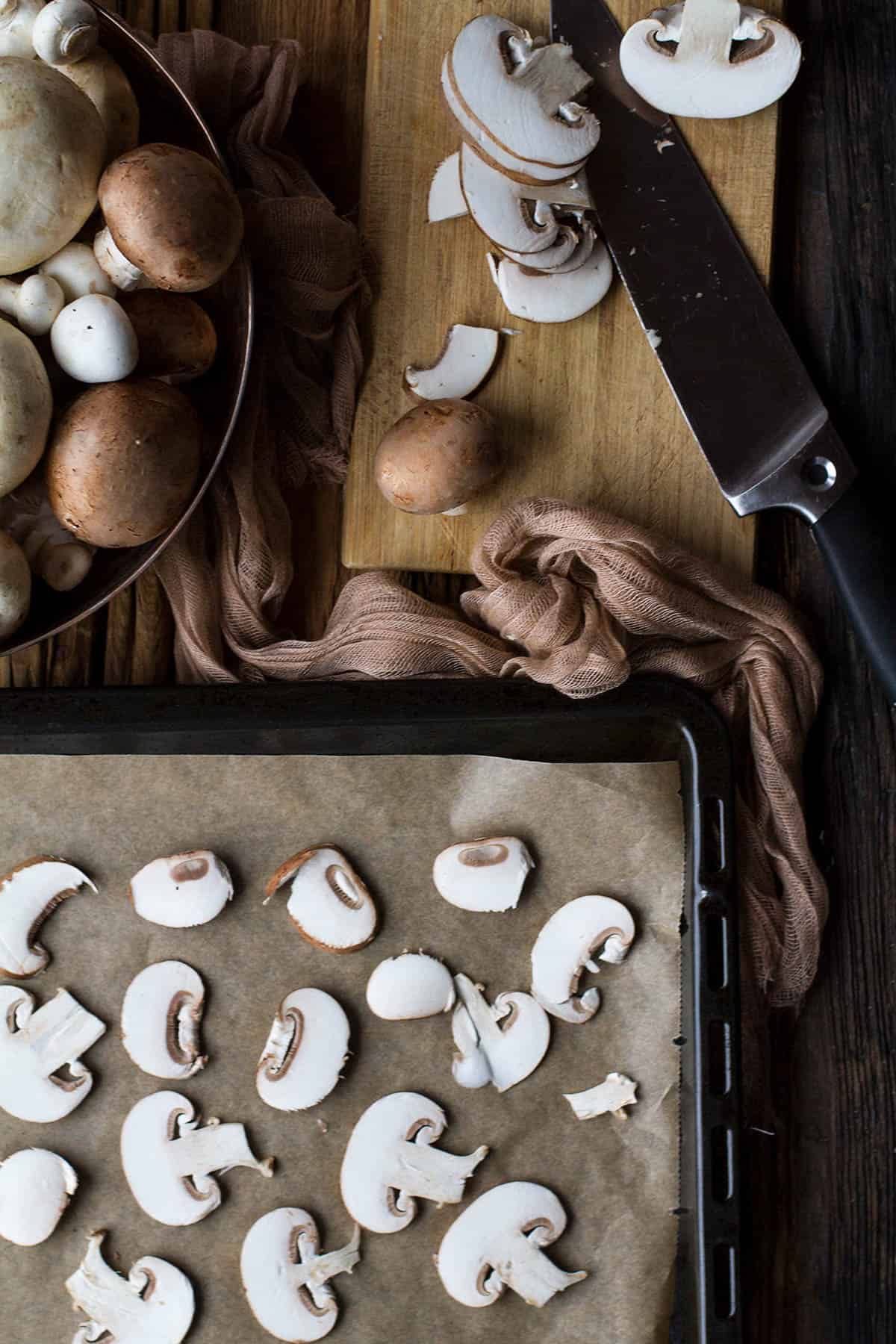 A baking sheet with sliced mushrooms.