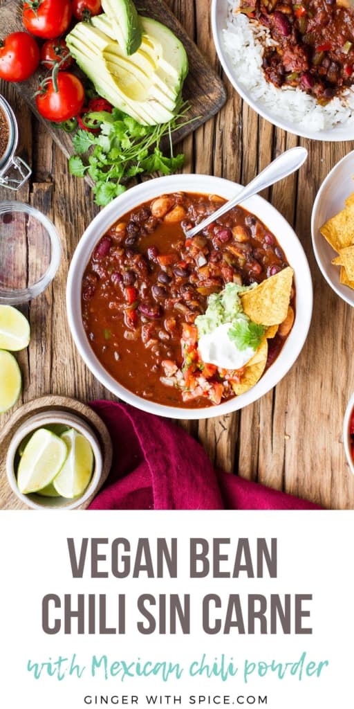 Bowl of vegan chili, topped with sour cream and guacamole. Pinterest pin.