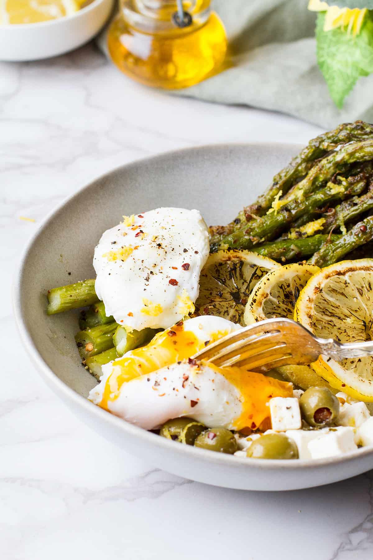 Cut open the poached egg with asparagus.