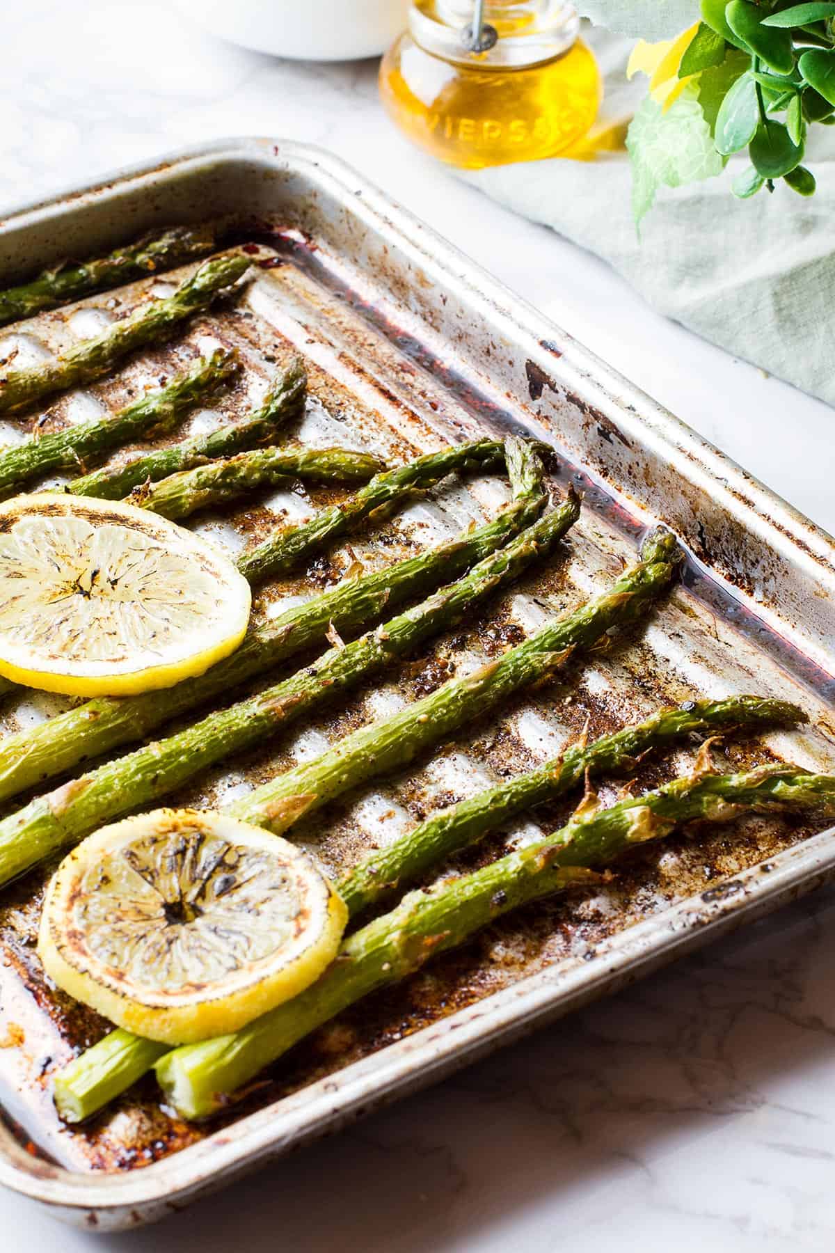 Old baking sheet with asparagus, backlighting.