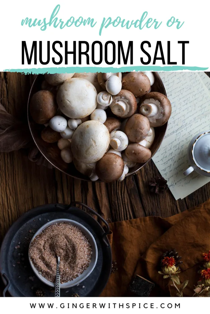 A big bowl of various mushrooms and a small bowl with mushroom salt on a large wooden table. Pinterest pin with text above.