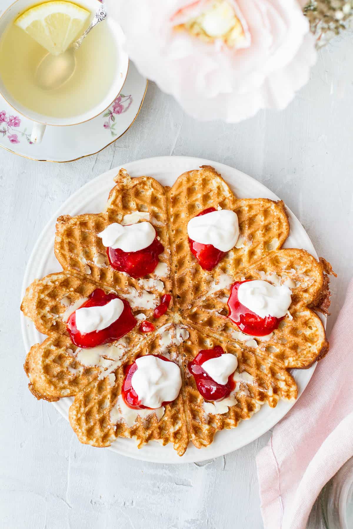One waffle with sour cream and strawberry jam seen from above.