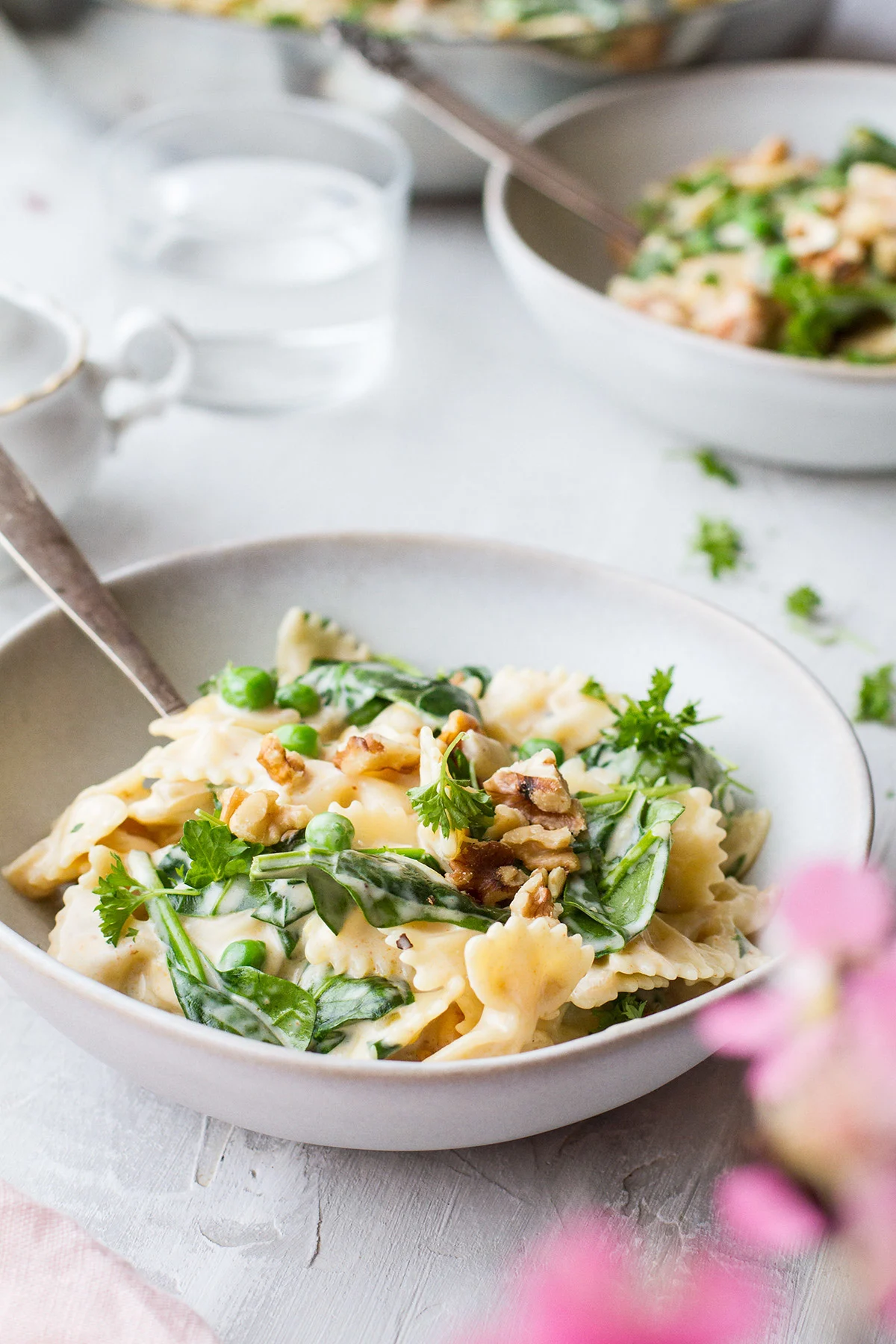 Two bowls with spring pasta and peas.