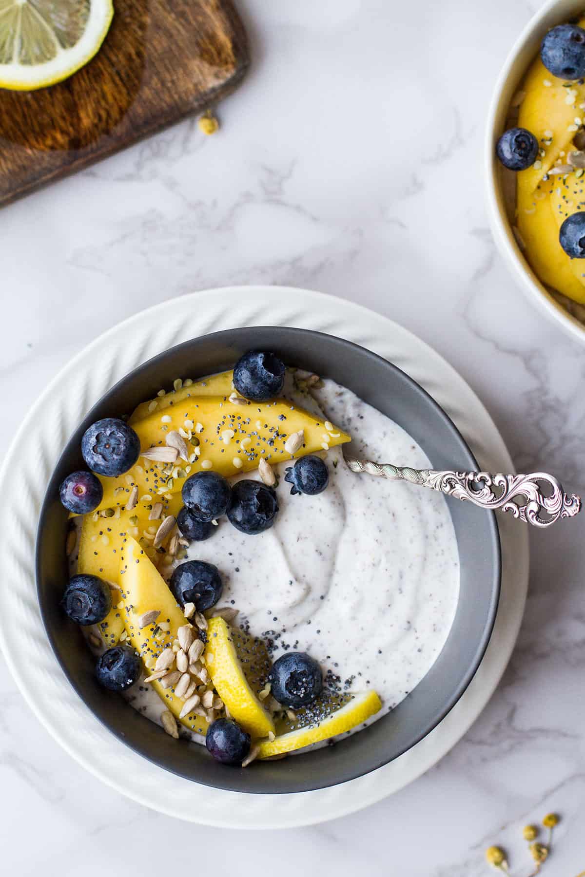 Bowl of chia yogurt, chunks of mango and blueberries. Seen from above.
