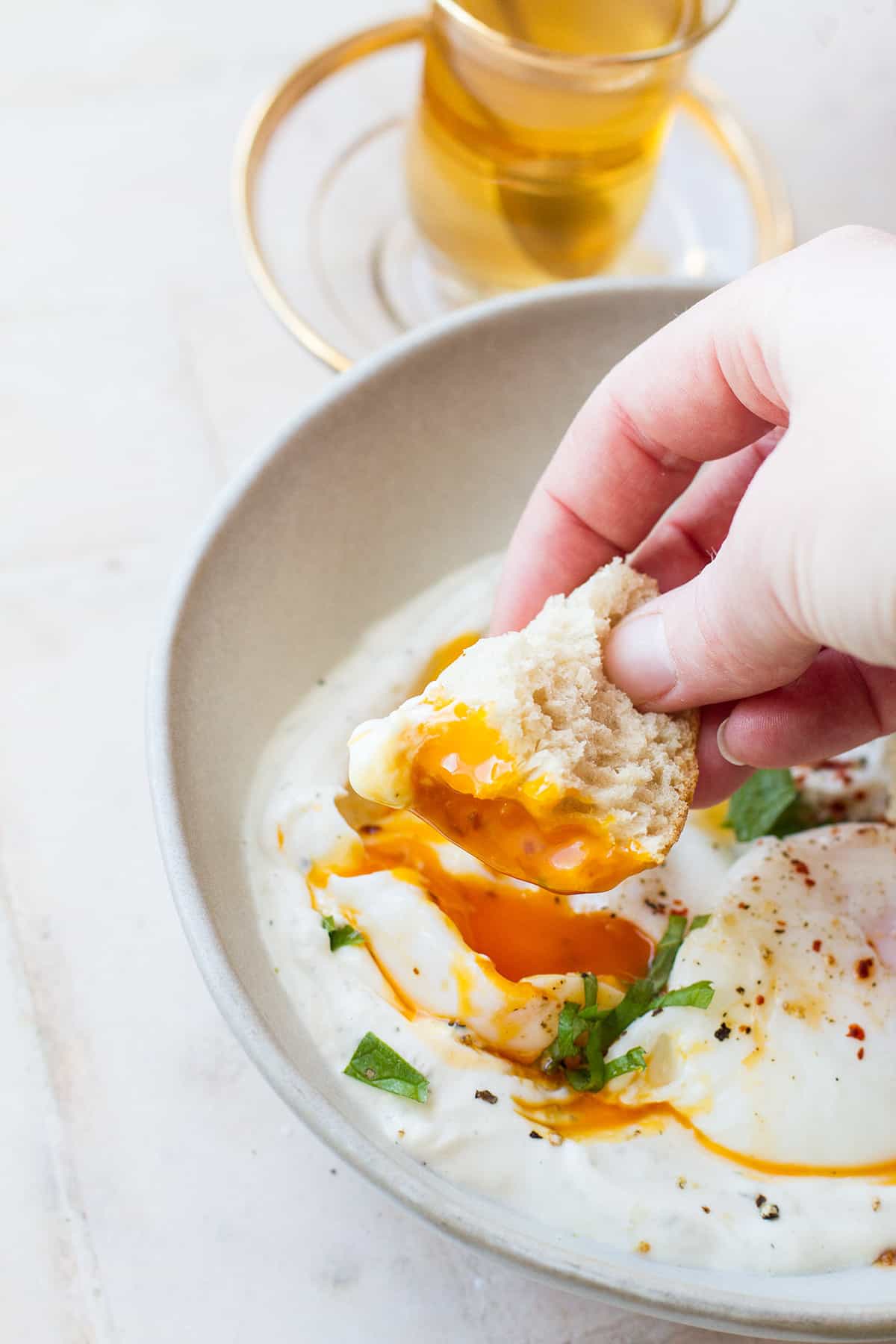 Dipping crusty bread in poached egg yolk.