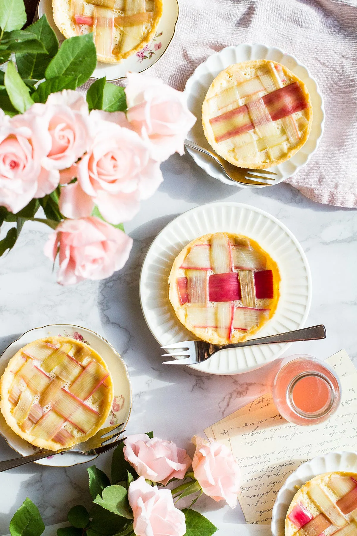Five tarts with rhubarb on top shaped in a lattice pattern.
