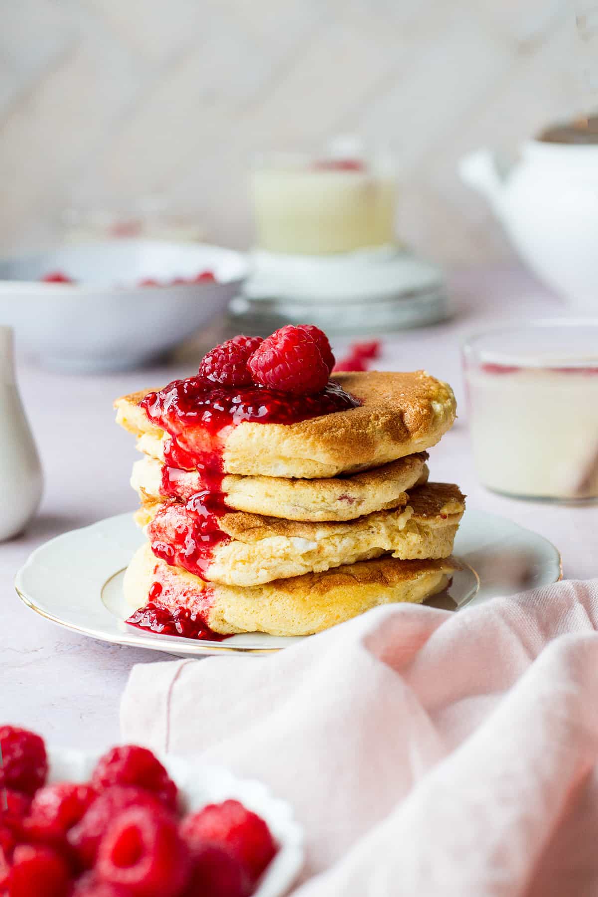 Stack of soufflé pancakes with raspberry sauce on top.