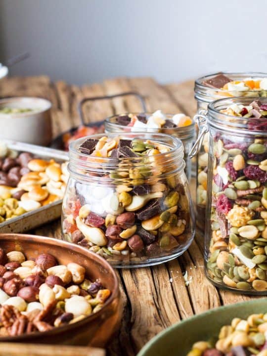Glass jars filled with different trail mixes.