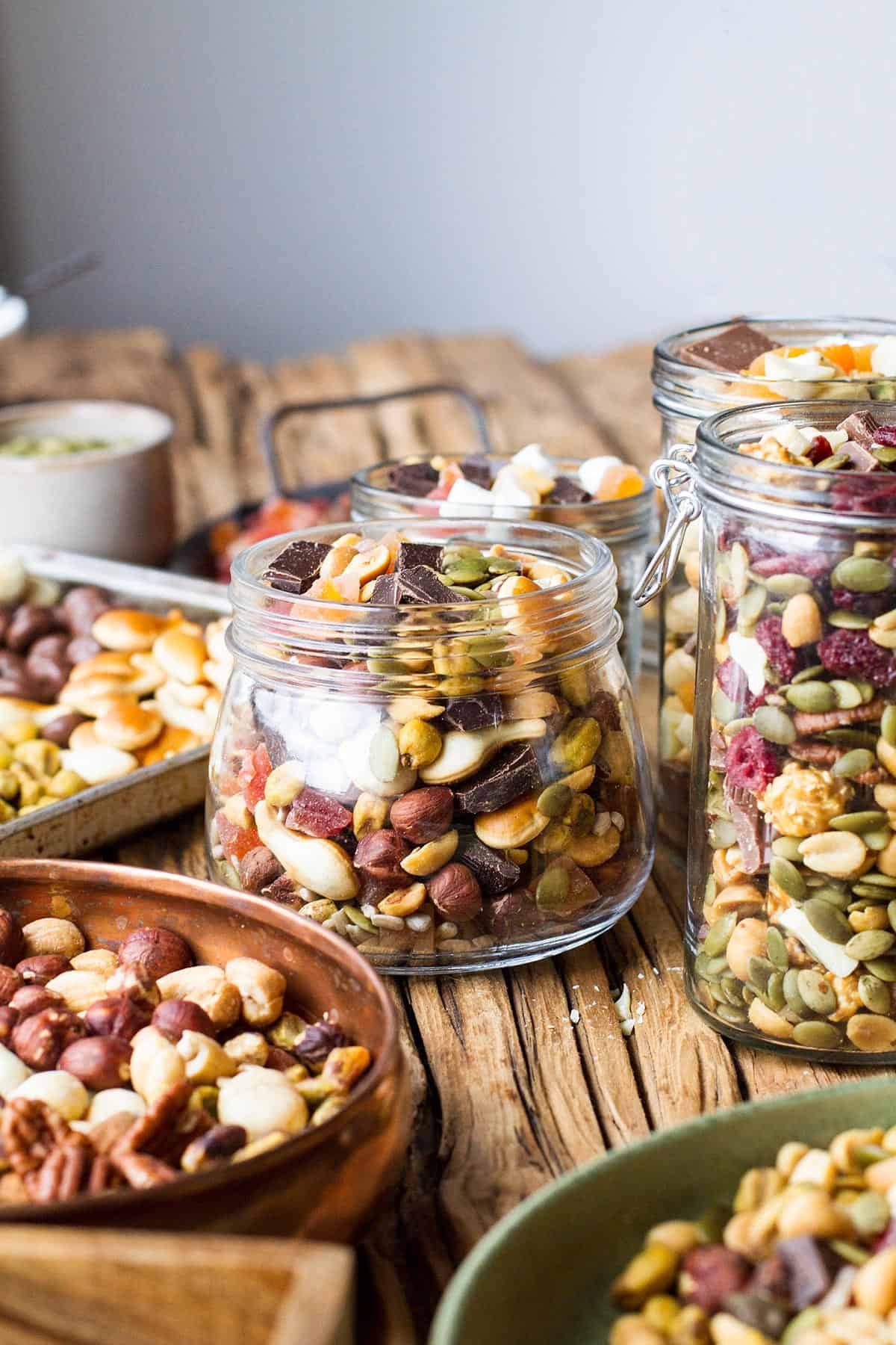 Glass jars filled with different trail mixes.