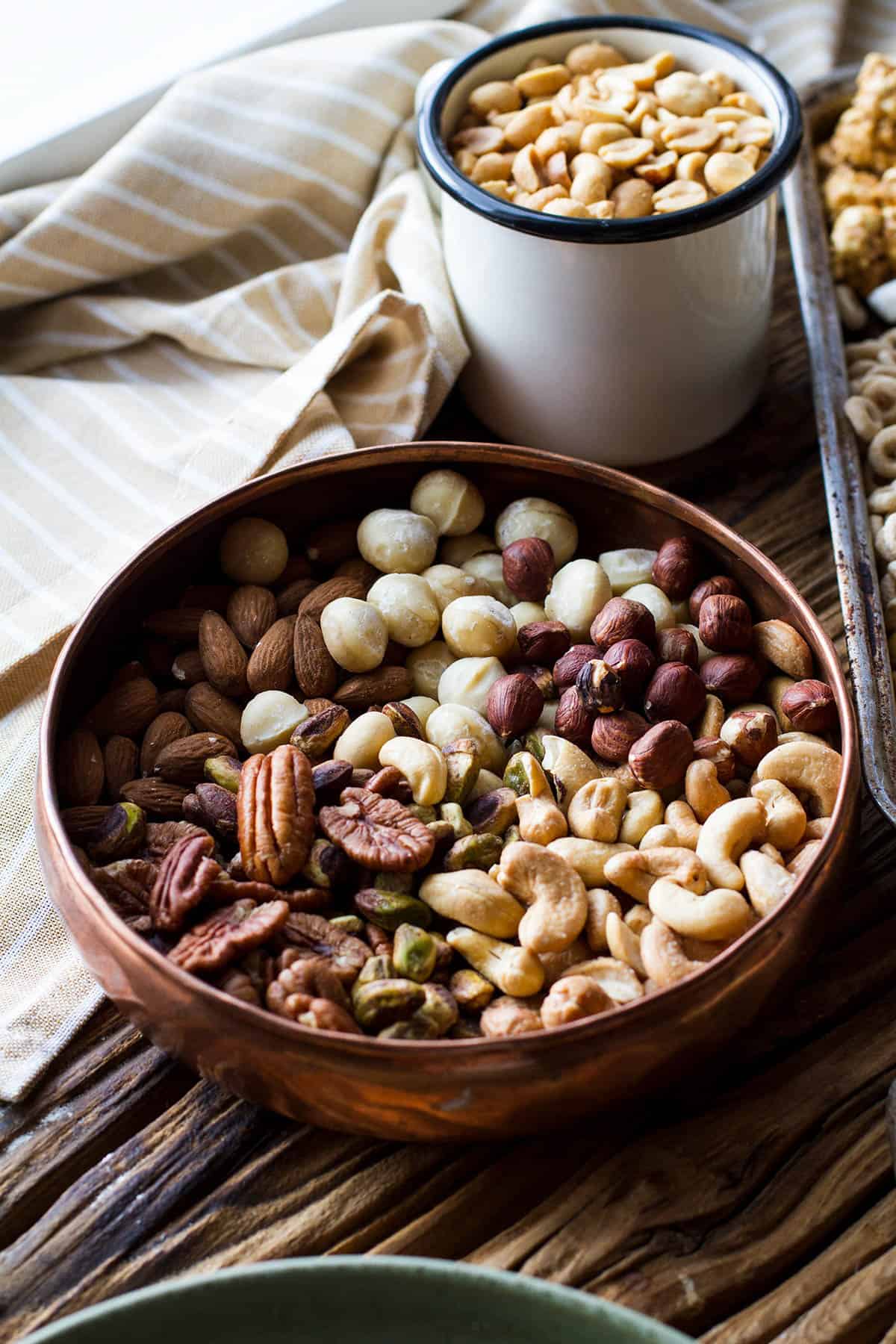 A copper bowl with various nuts.