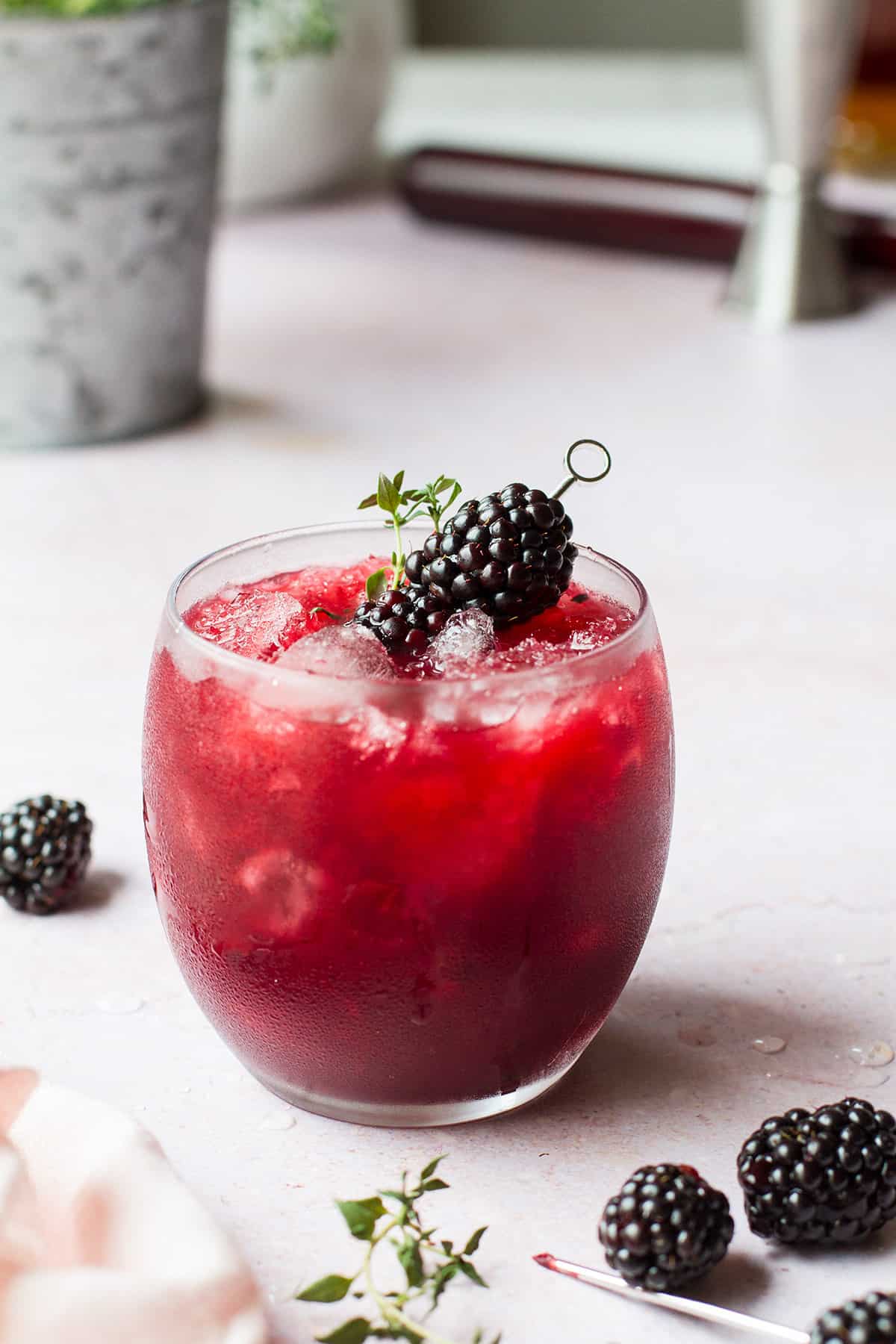 Blackberry bourbon smash with a pink background.