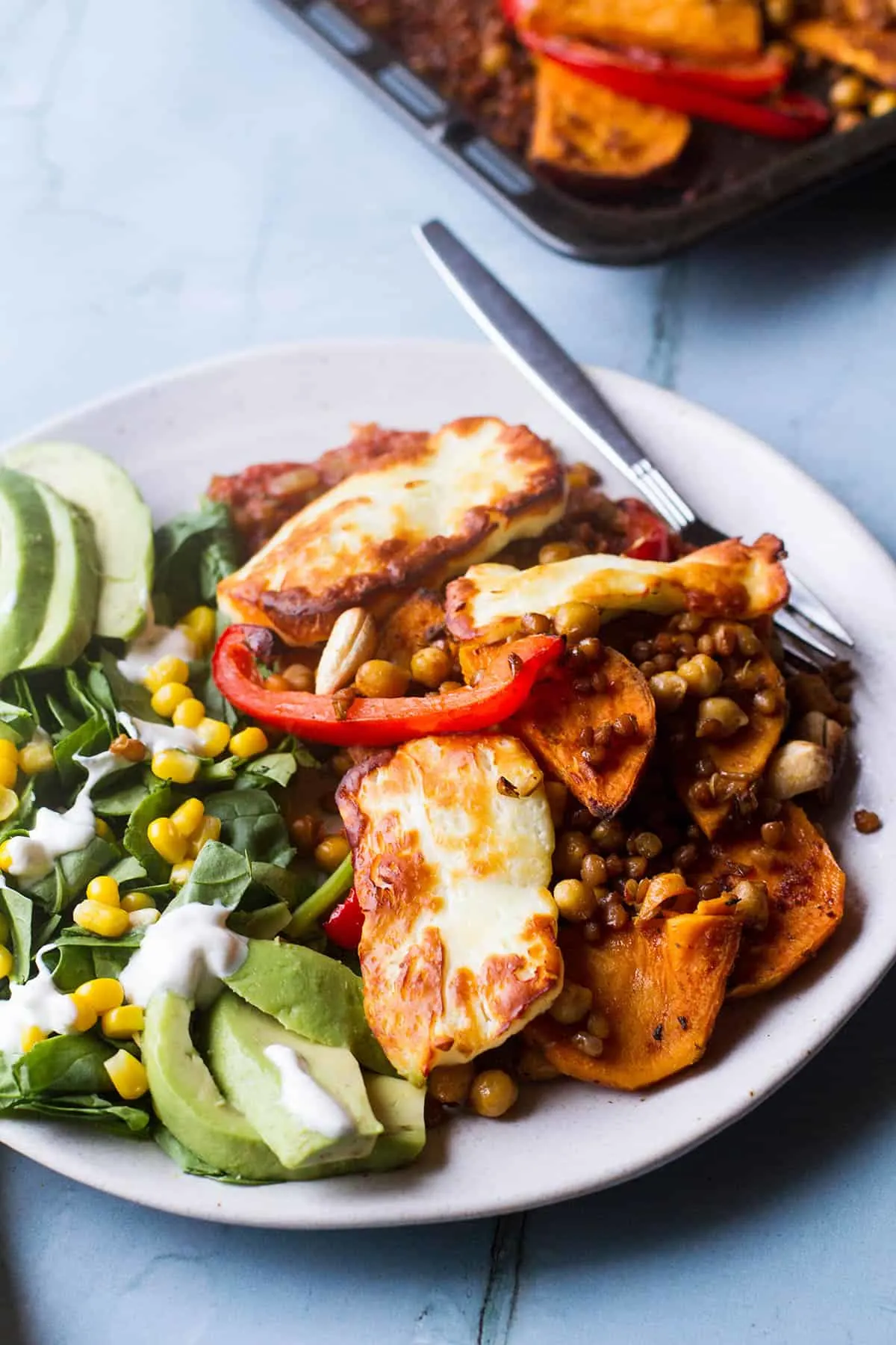 Sweet potato and bell pepper bake and a side salad on a white plate.