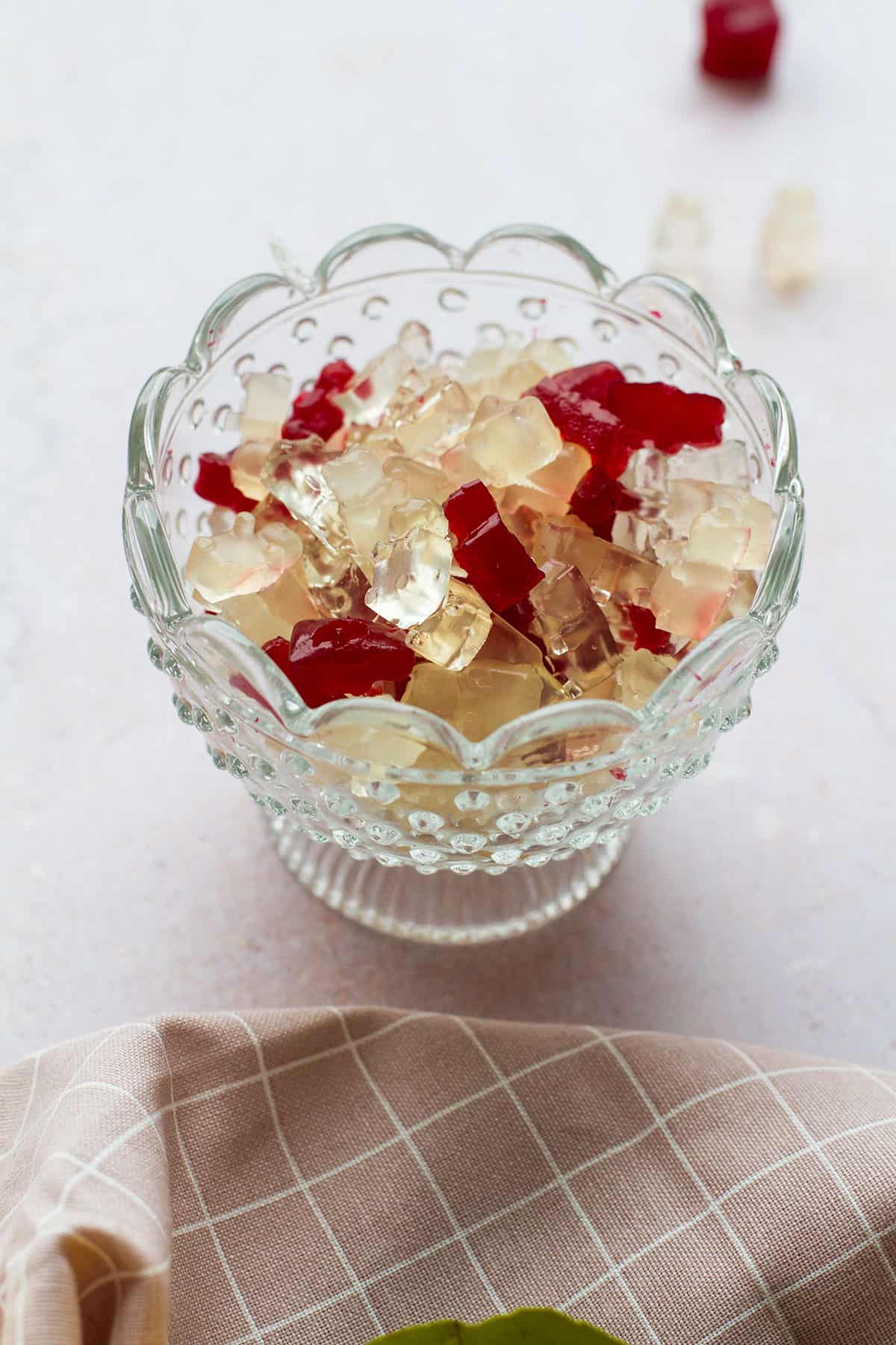 Glass bowl with gummy bears in three different colors.