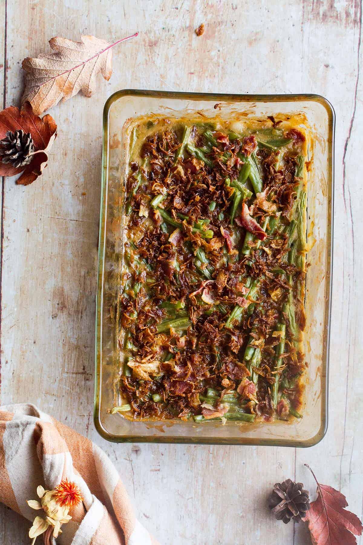A glass baking dish with green bean casserole seen from above.