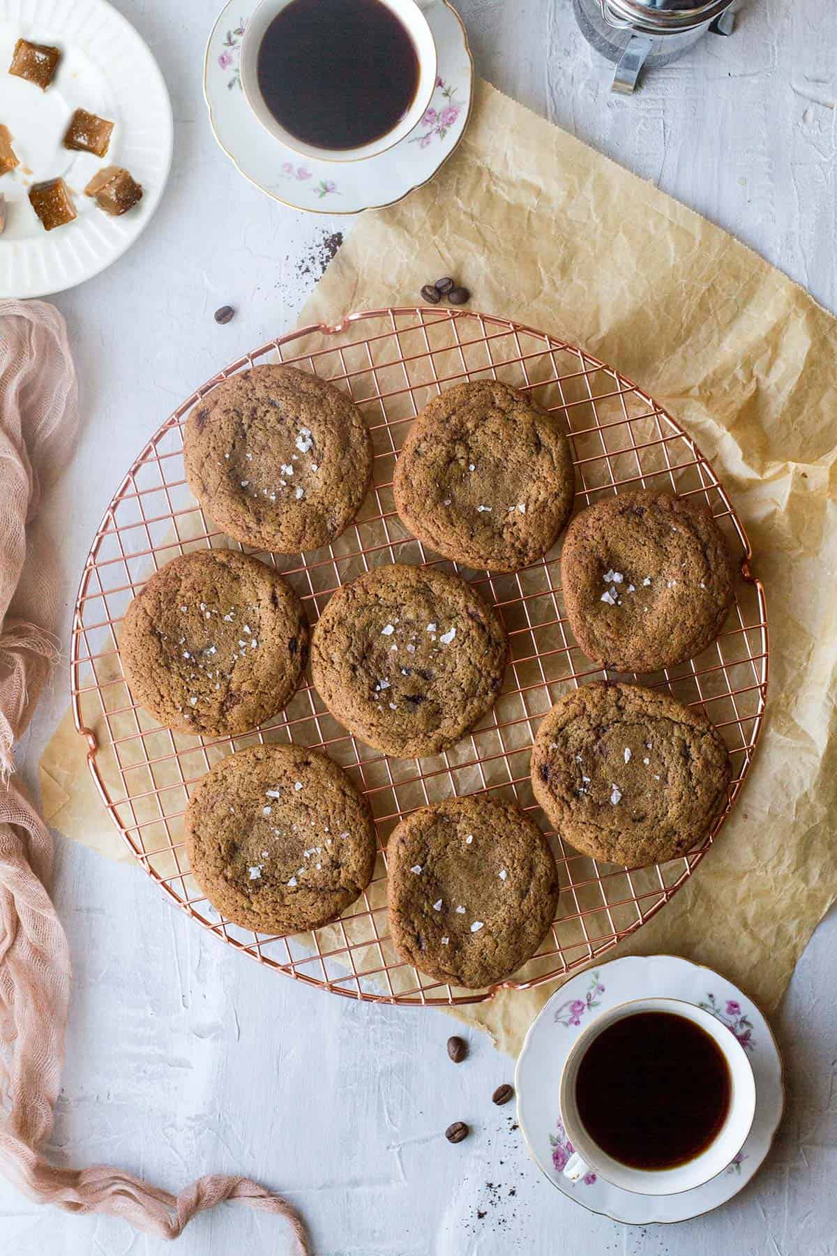 Salted caramel-filled coffee cookies on a cooling rack.
