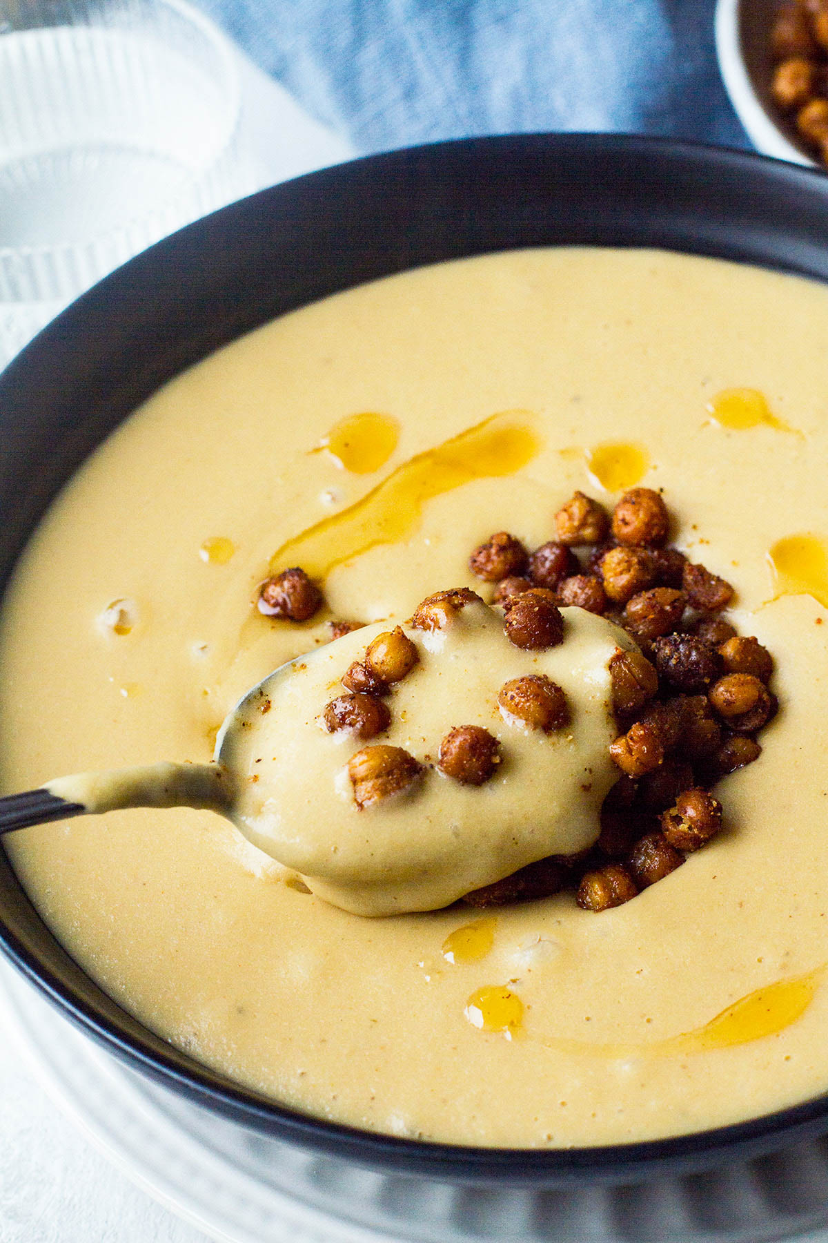 A spoonful of chickpea soup and roasted chickpeas.