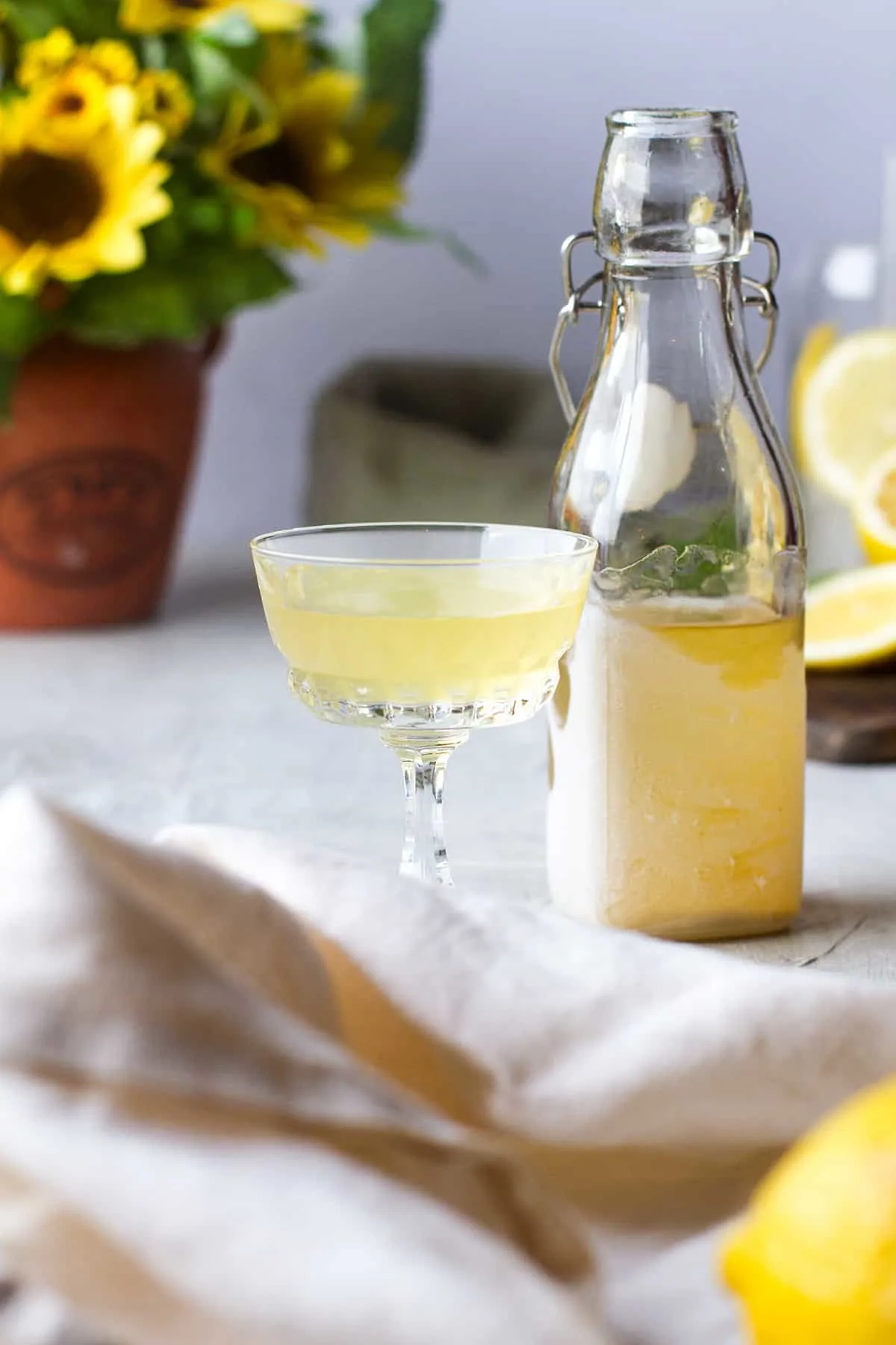A vintage glass with limoncello and a bottle of chilled limoncello on the side.