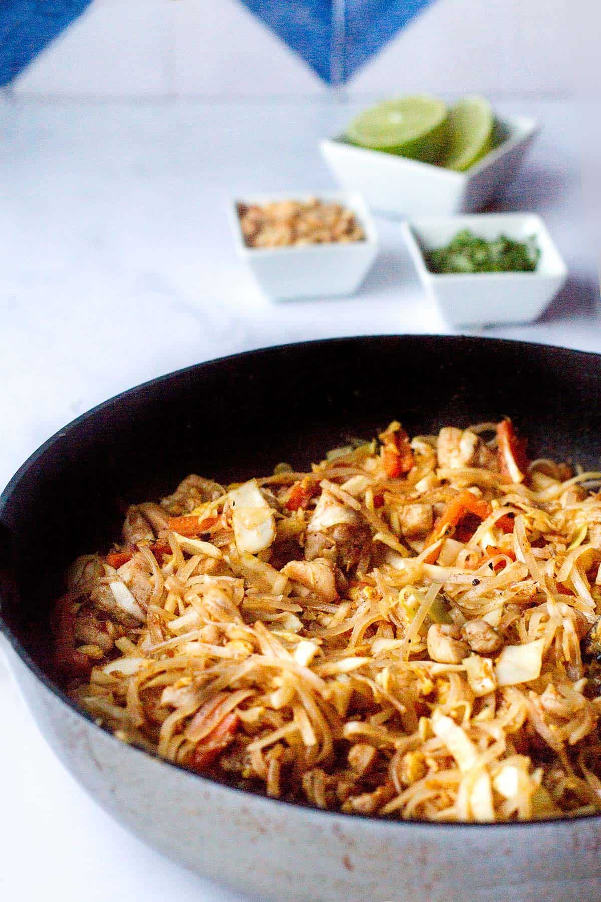Skillet with finished chicken pad thai.