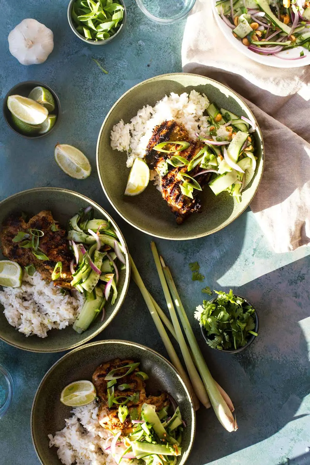 Three shallow green bowls with lemongrass chicken serving suggestion.