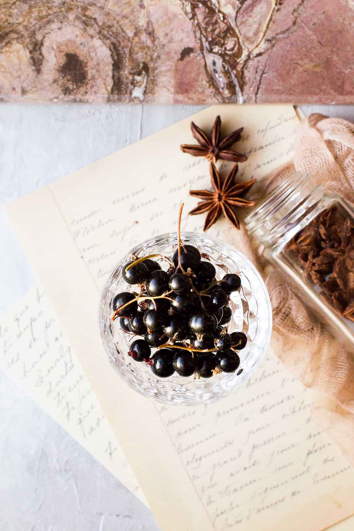 A glass jar of fresh blackcurrants.