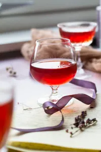 A red liqueur in a round glass, backlighting.