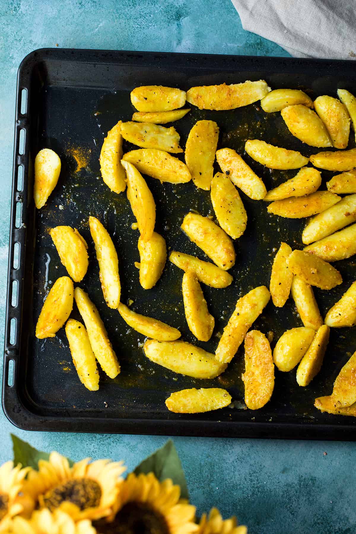 Fingerling potatoes mixed with turmeric on a baking sheet.
