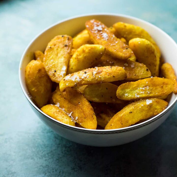 Small bowl of crispy roasted fingerling potatoes with turmeric.