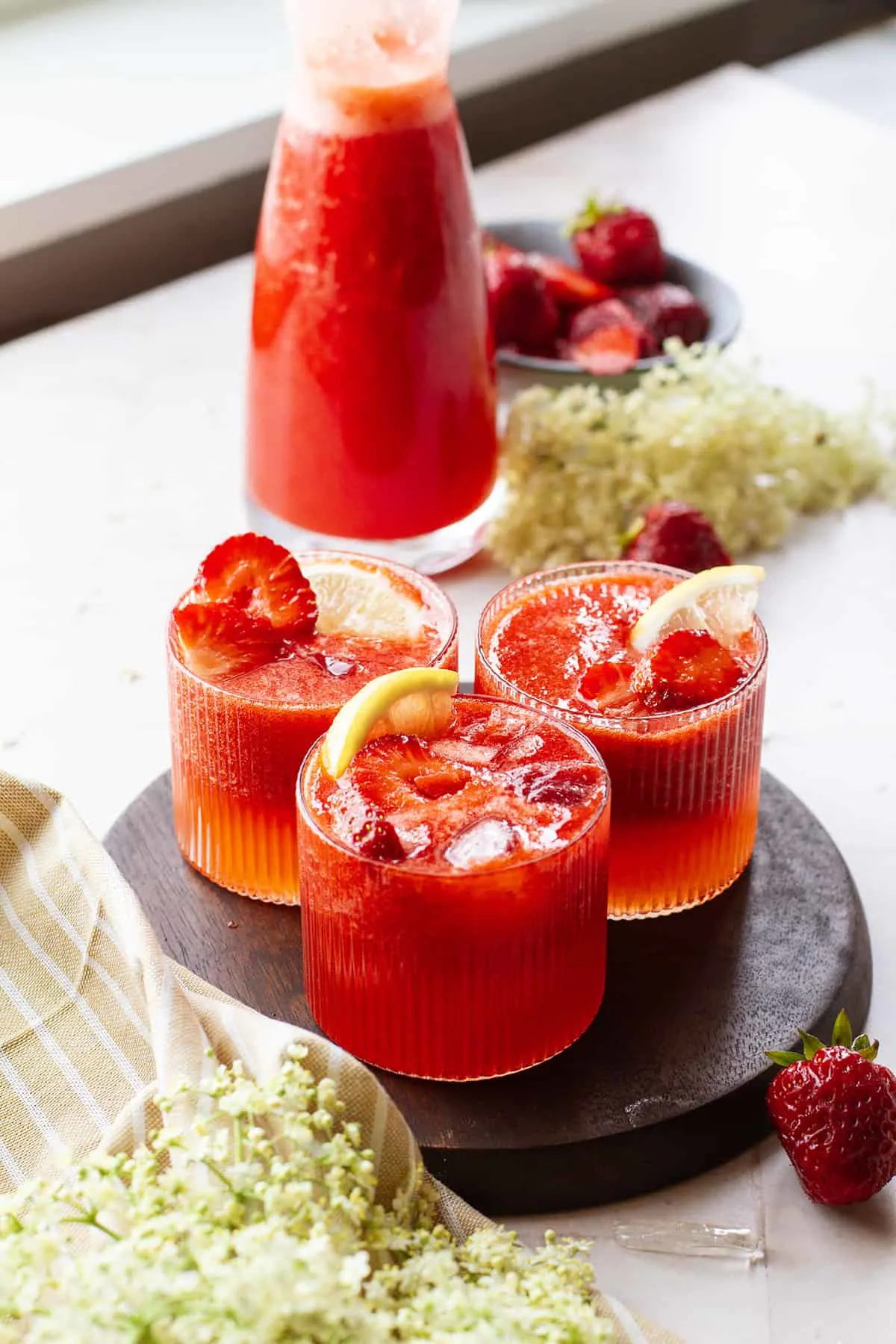Three glasses with elderflower strawberry lemonade.