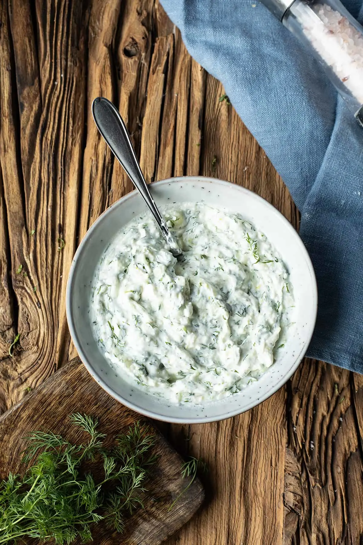 Bowl of tzatziki on a wooden table.