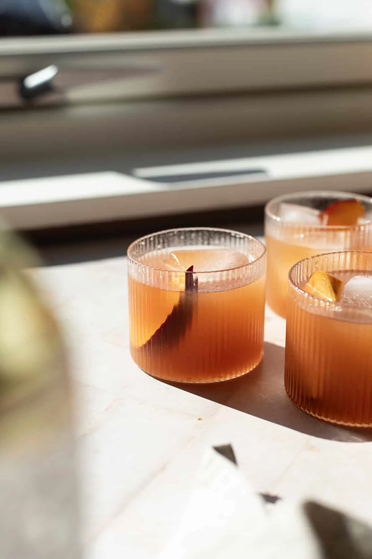 Peach tea in a rocks glass, with backlighting.