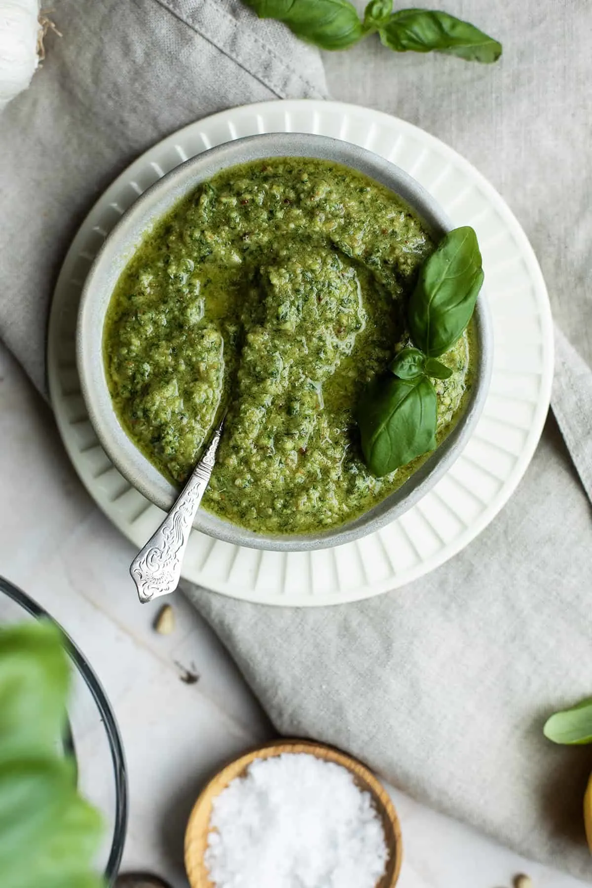 A small white bowl with homemade basil pesto.