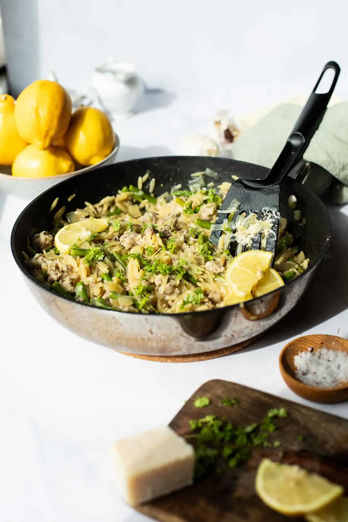 A skillet with lemon parmesan sausage orzo.