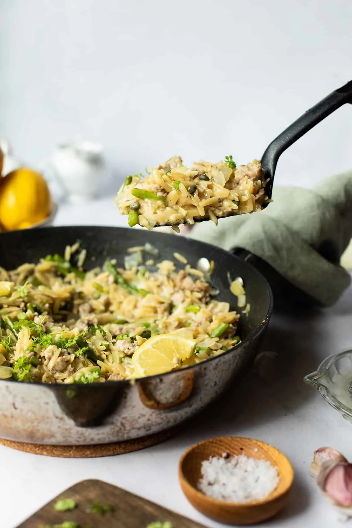 Spatula taking a serving of lemon parmesan orzo.