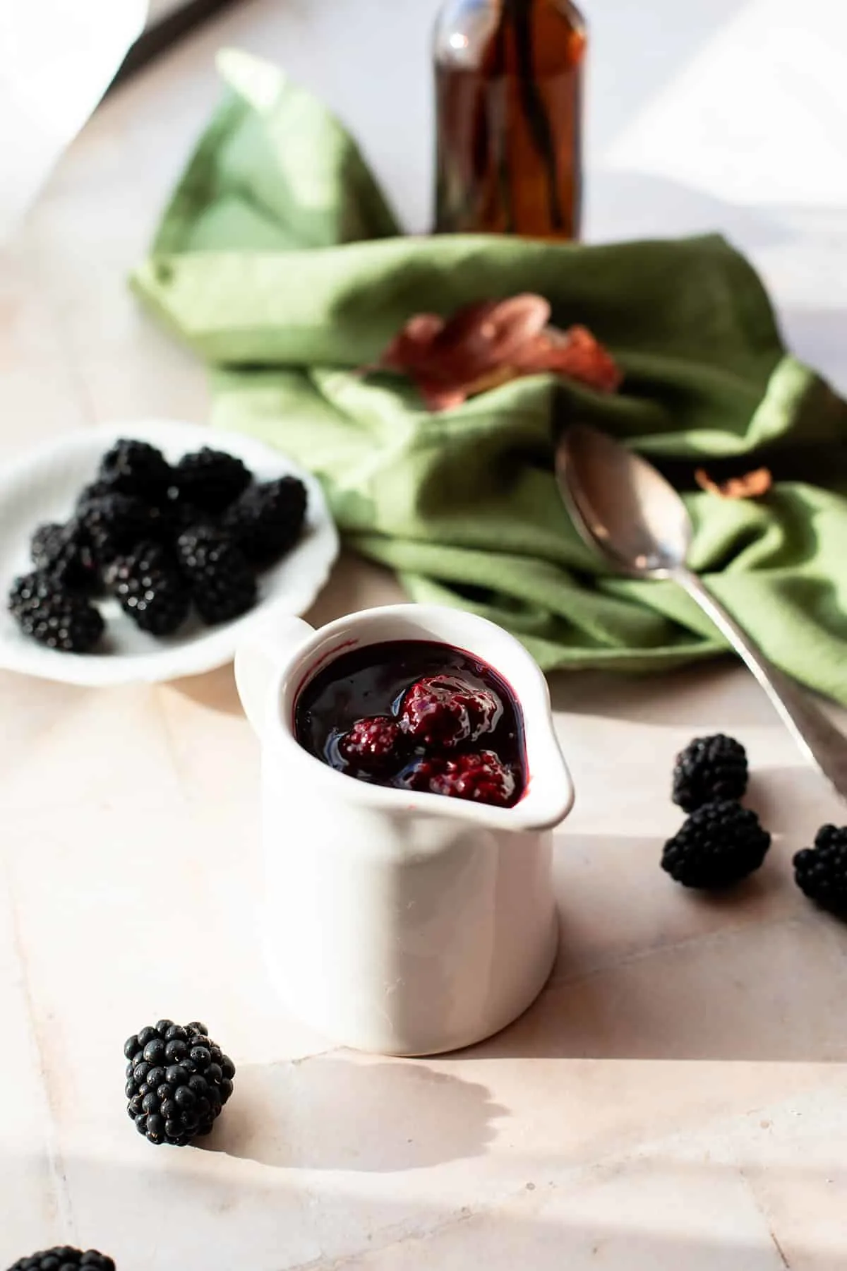 A small jug with blackberry sauce.