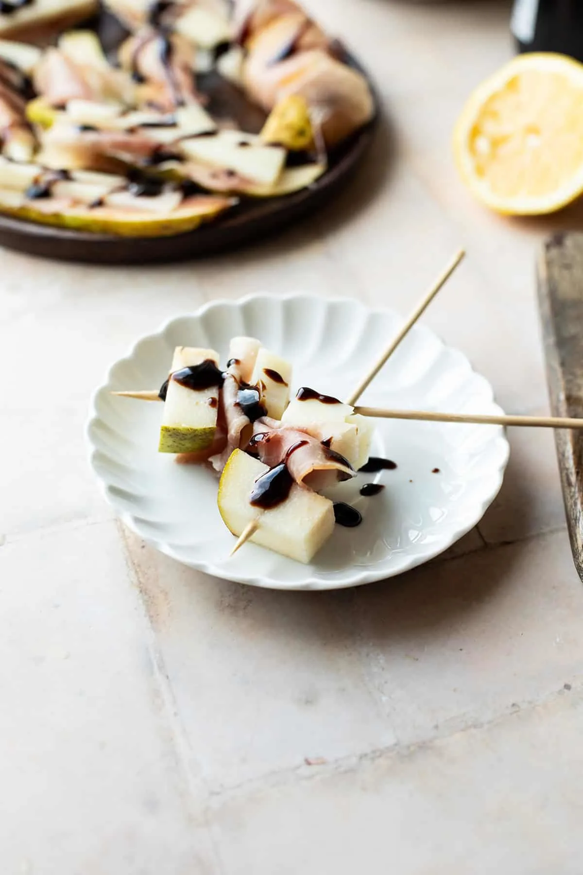 Close-up of a small plate with skewers with pear and manchego.
