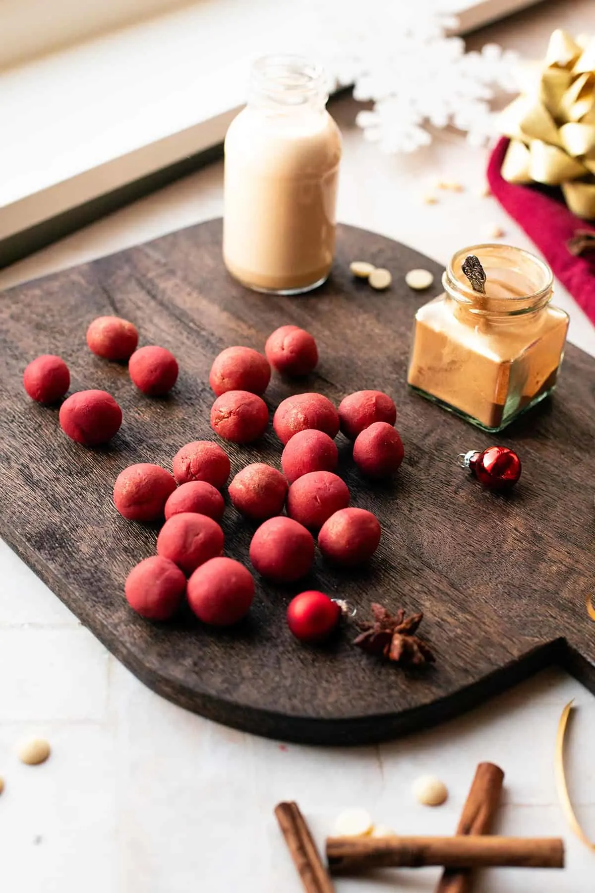 Balls of red baileys eggnog truffles on a wooden board.