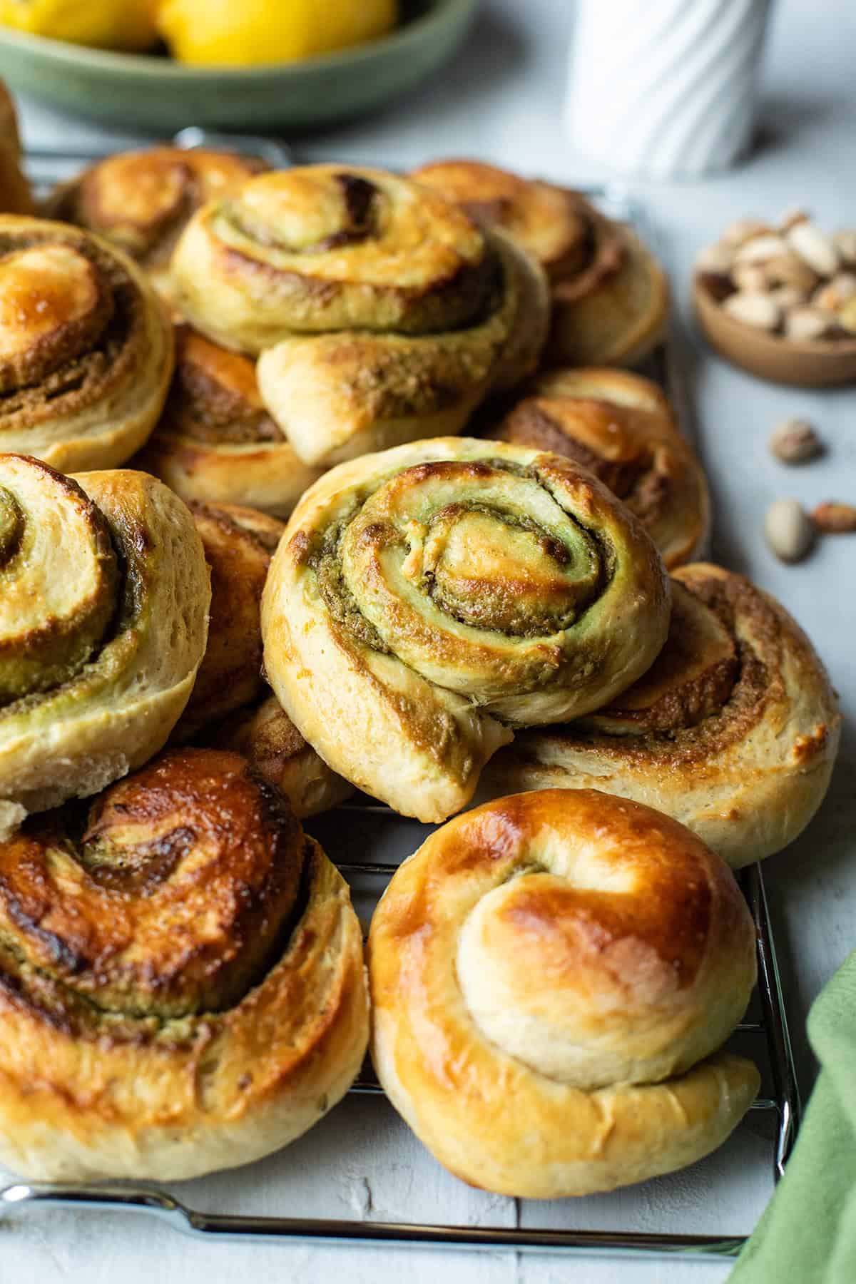 Close up of a cooling rack with stacks of pistachio rolls.