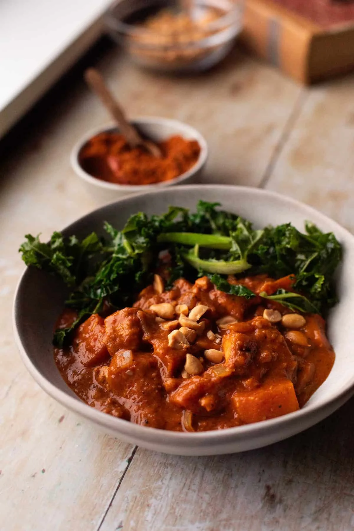 Serving bowl with berbere chicken and garlic kale.
