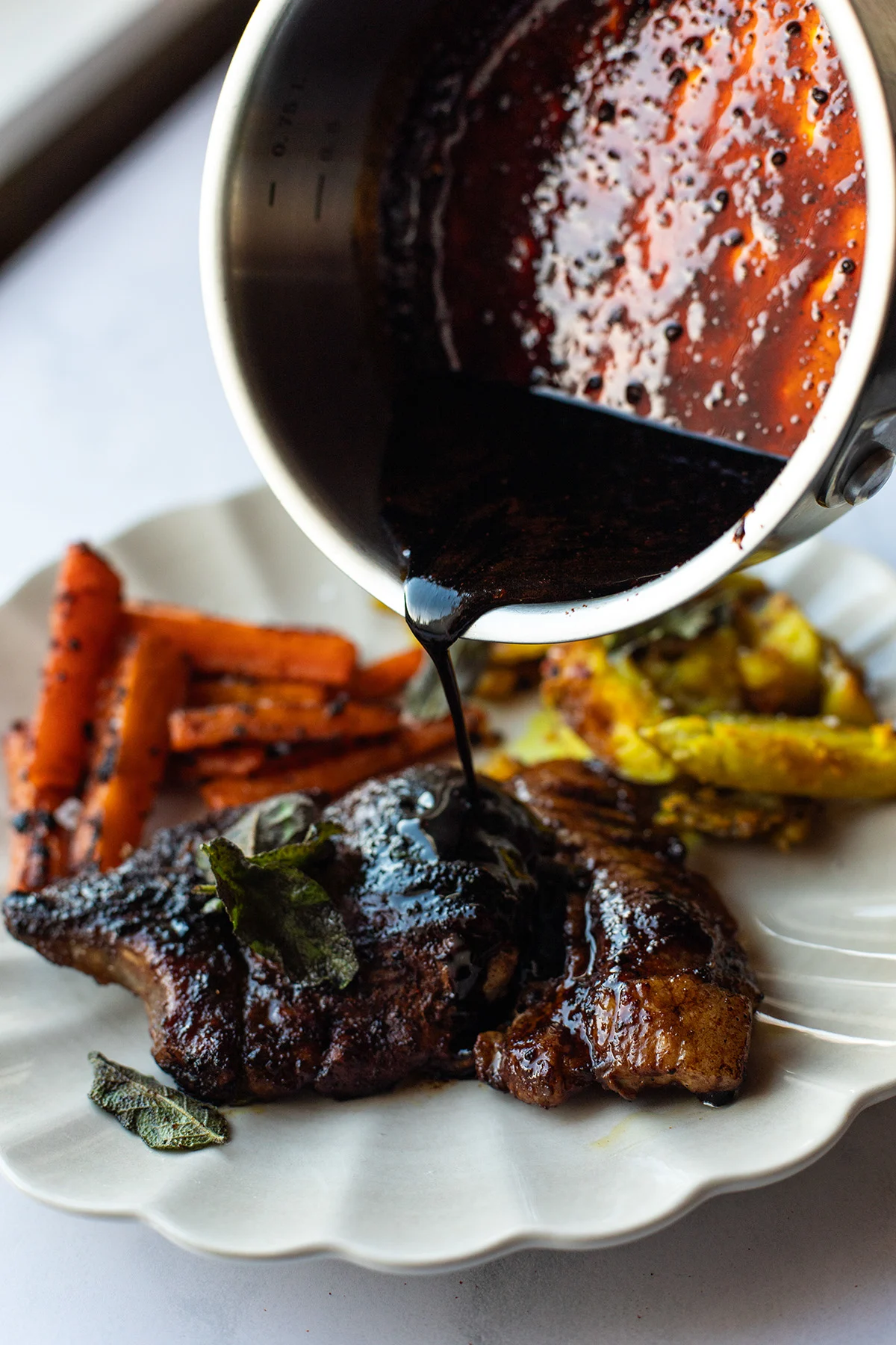 Pouring leftover glaze over the pork chops.