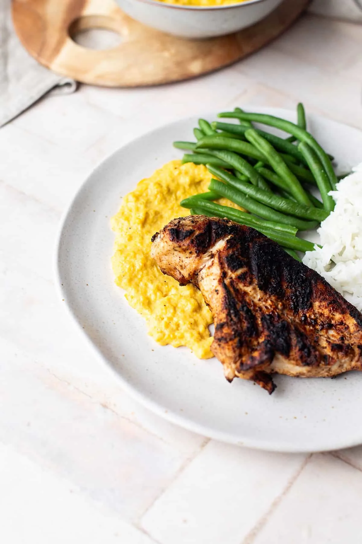 Finished dish (without sauce) to showcase a serving suggestion for creamed corn with green beans, rice and grilled chicken.