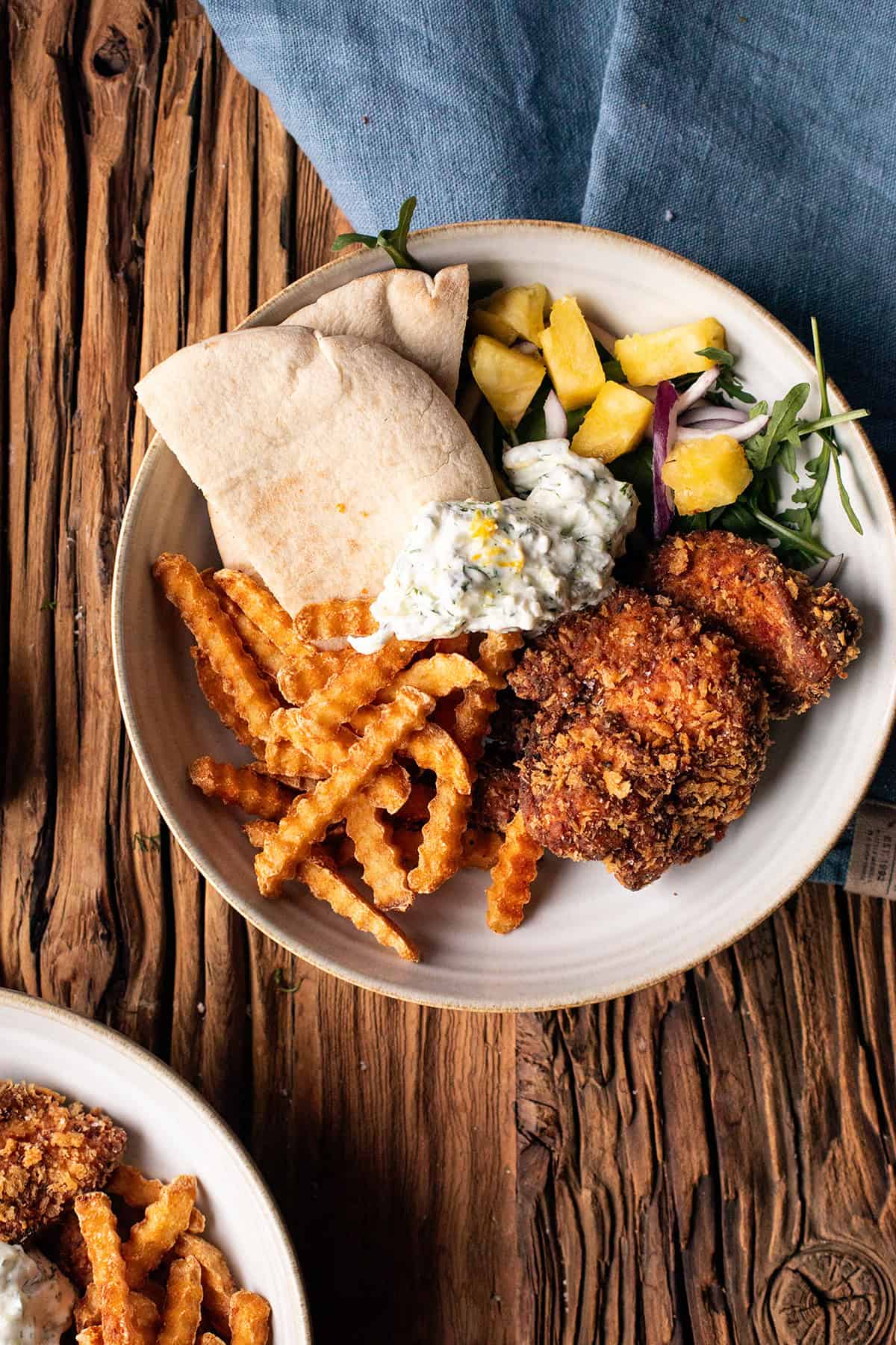 Serving suggestion for crispy cajun chicken with panko breading with fries and salad.