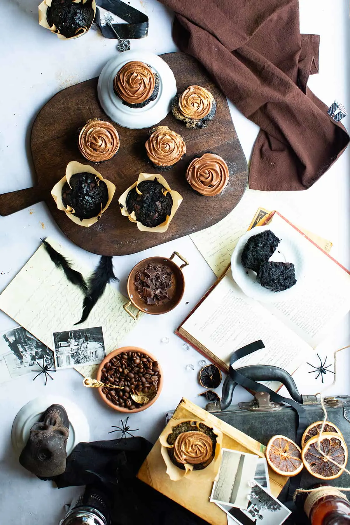 A cutting board with chocolate cupcakes seen from above.