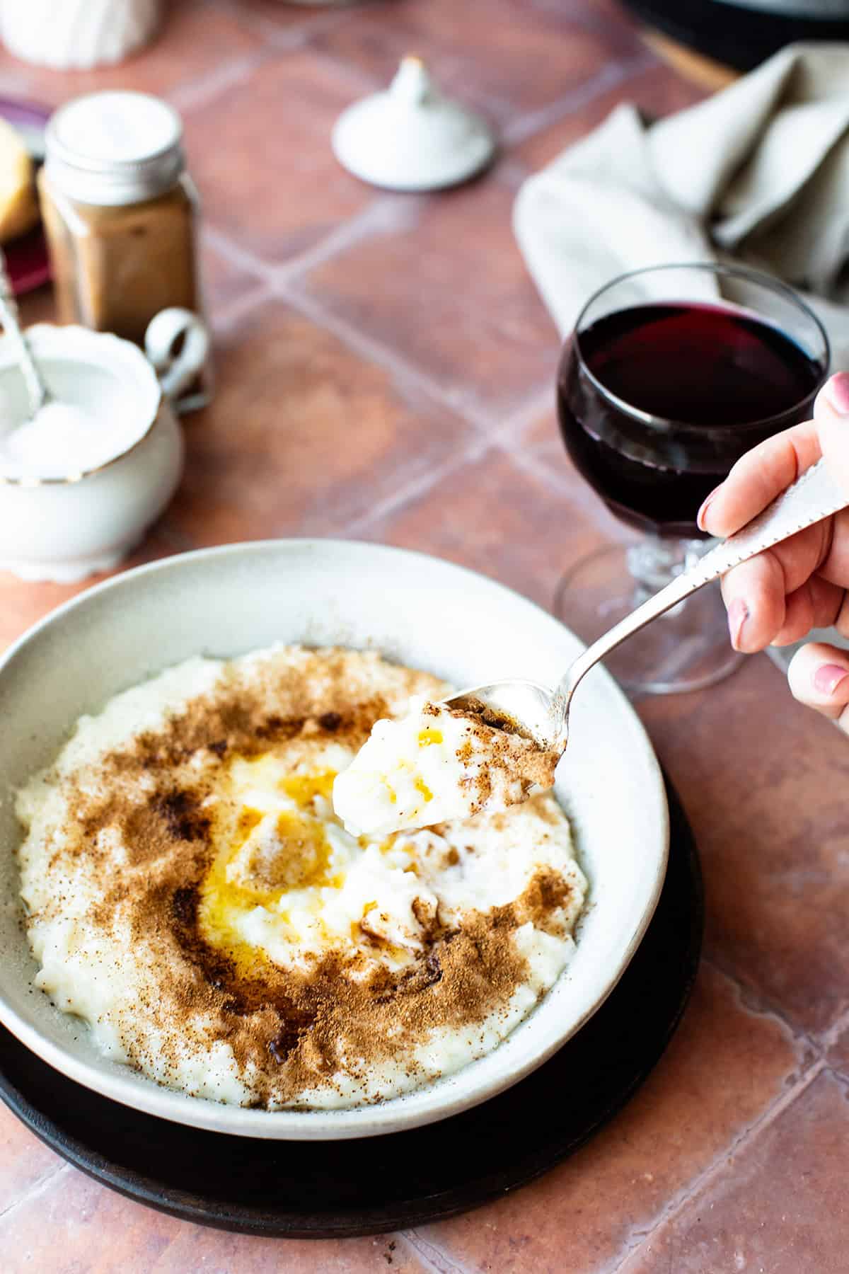 Taking a spoonful of rice porridge from a serving bowl.