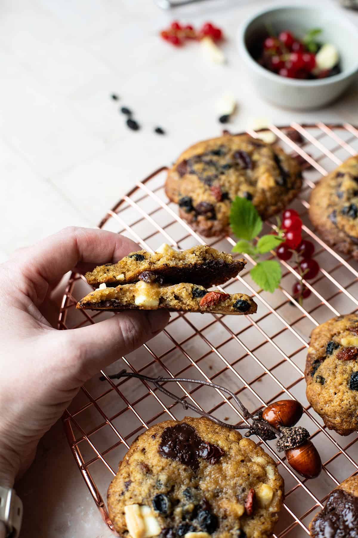 Hand holding a snapped open cookie to show the texture.