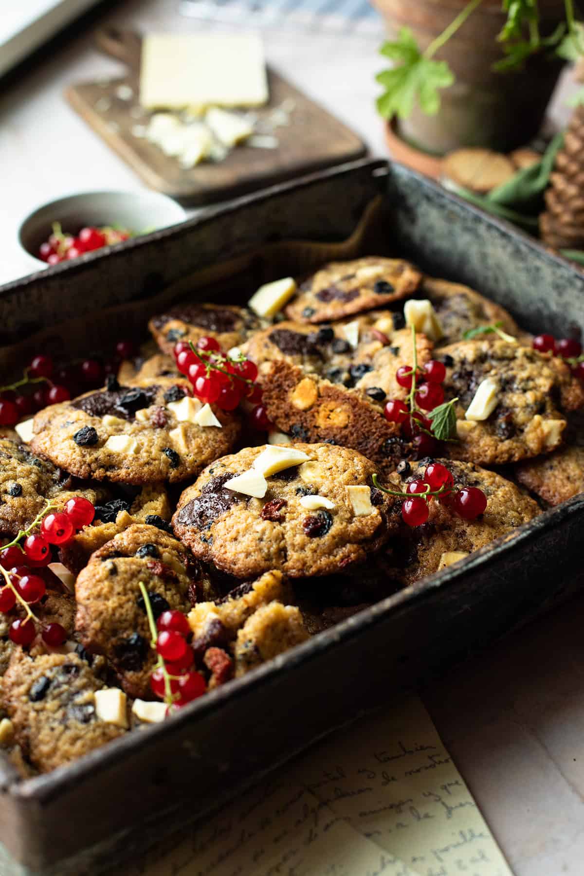 Metal tray with dried berries cookies and garnished with fresh red currants.
