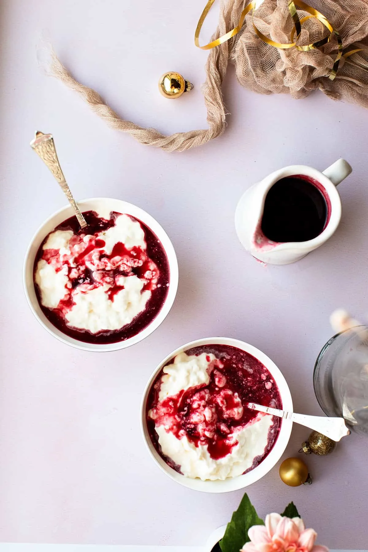 Two serving bowls with rice cream and berry sauce.