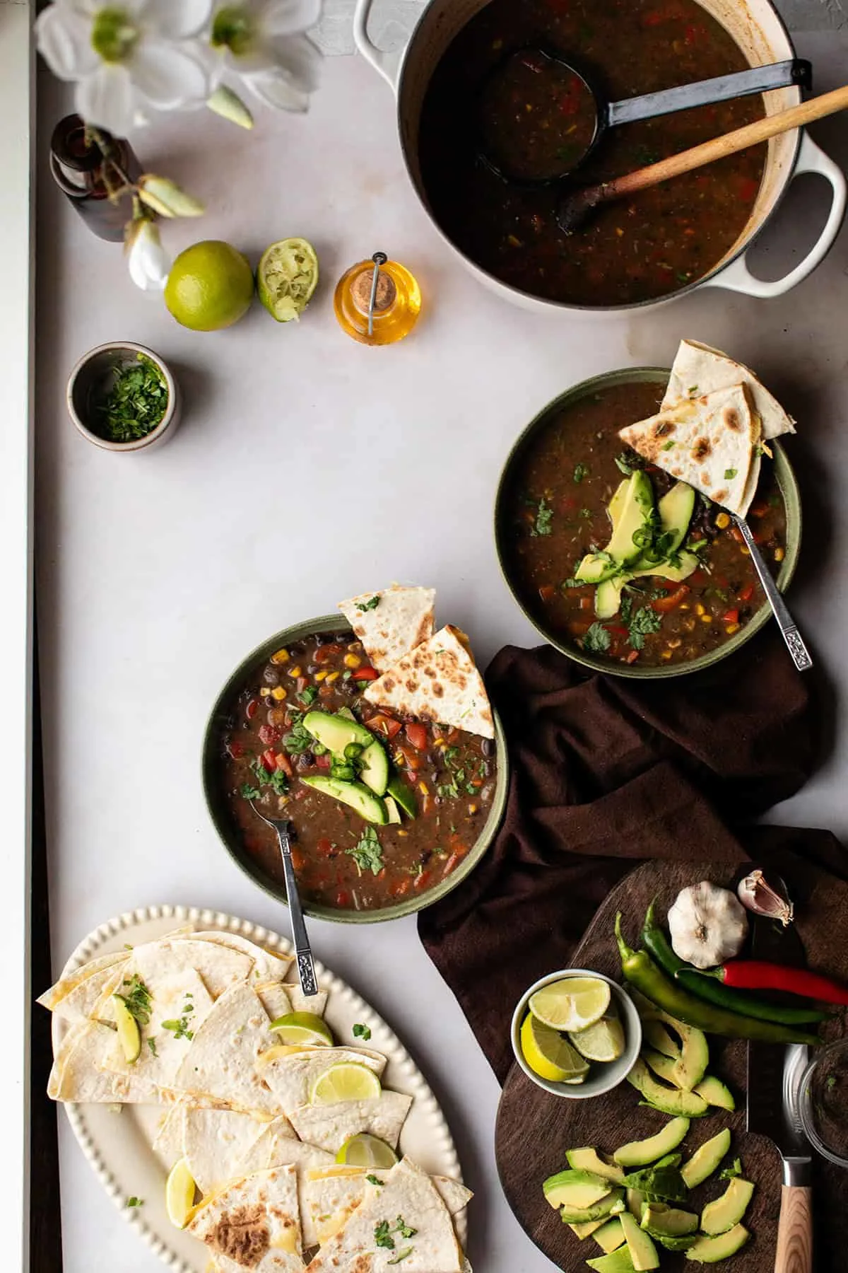 Two bowls with spicy black bean soup and a casserole seen from above.